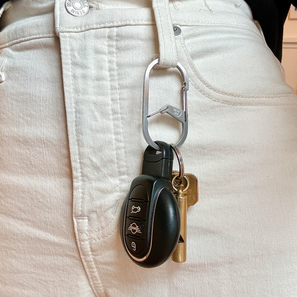 The Nite Ize G-Series Size 3 Dual Chamber Carabiner holds car and house keys while hanging from a pants belt loop.