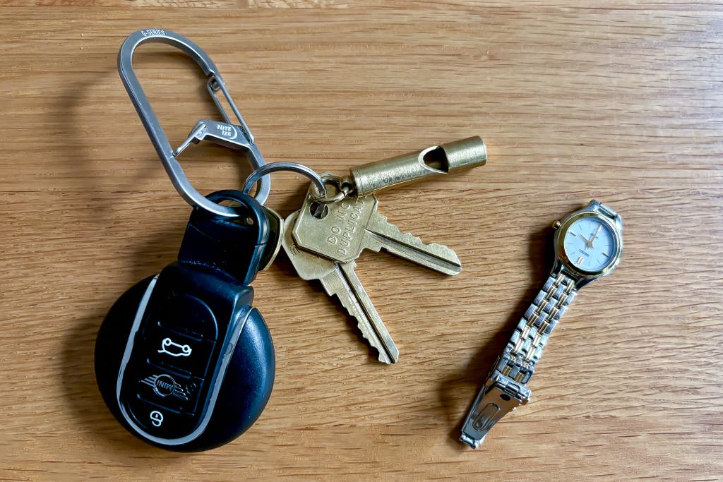 A set of keys on the Nite Ize G-Series Size 3 Dual Chamber Carbine next to a small watch.