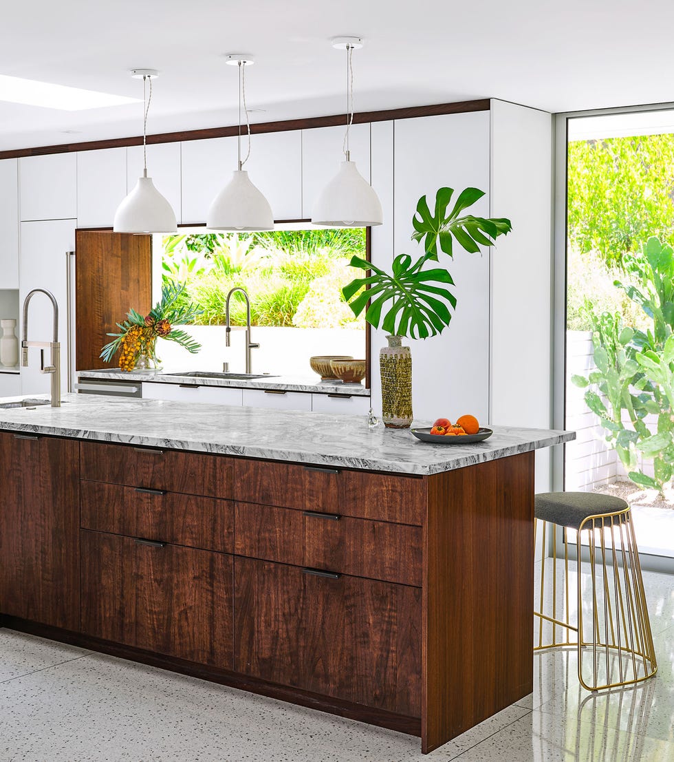 Luis Fernandez - Elle Decor Airy kitchen with island and three cone -shaped trailers over it