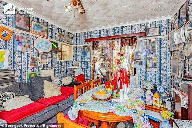 The topic is continued in the living room of the property with two bedrooms, like striped and flower blue paper adorn the walls next to different photos