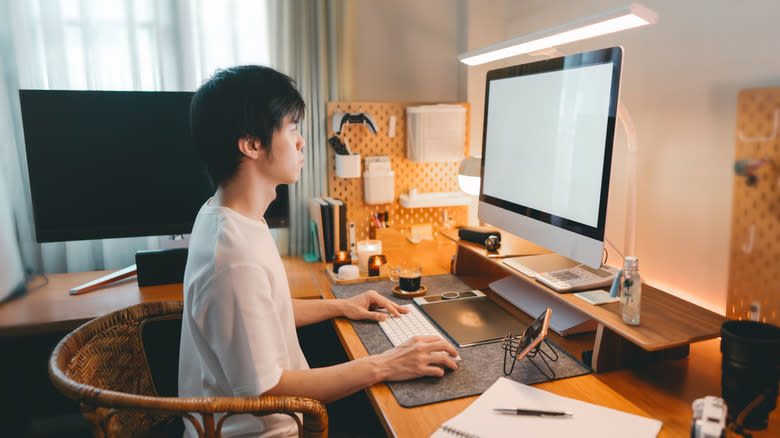 Man sits and works at a desk in a home office