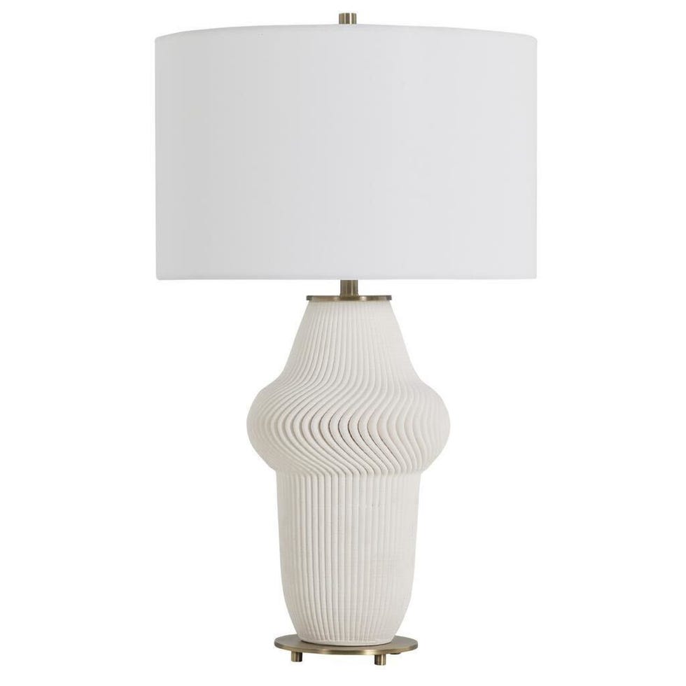 Table lamp with a structured ceramic base and a white cylindrical shade