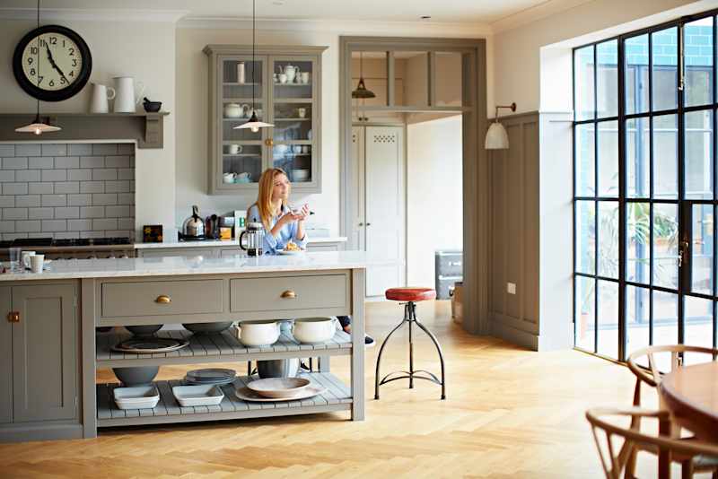Woman drinks coffee and breakfast in her kitchen