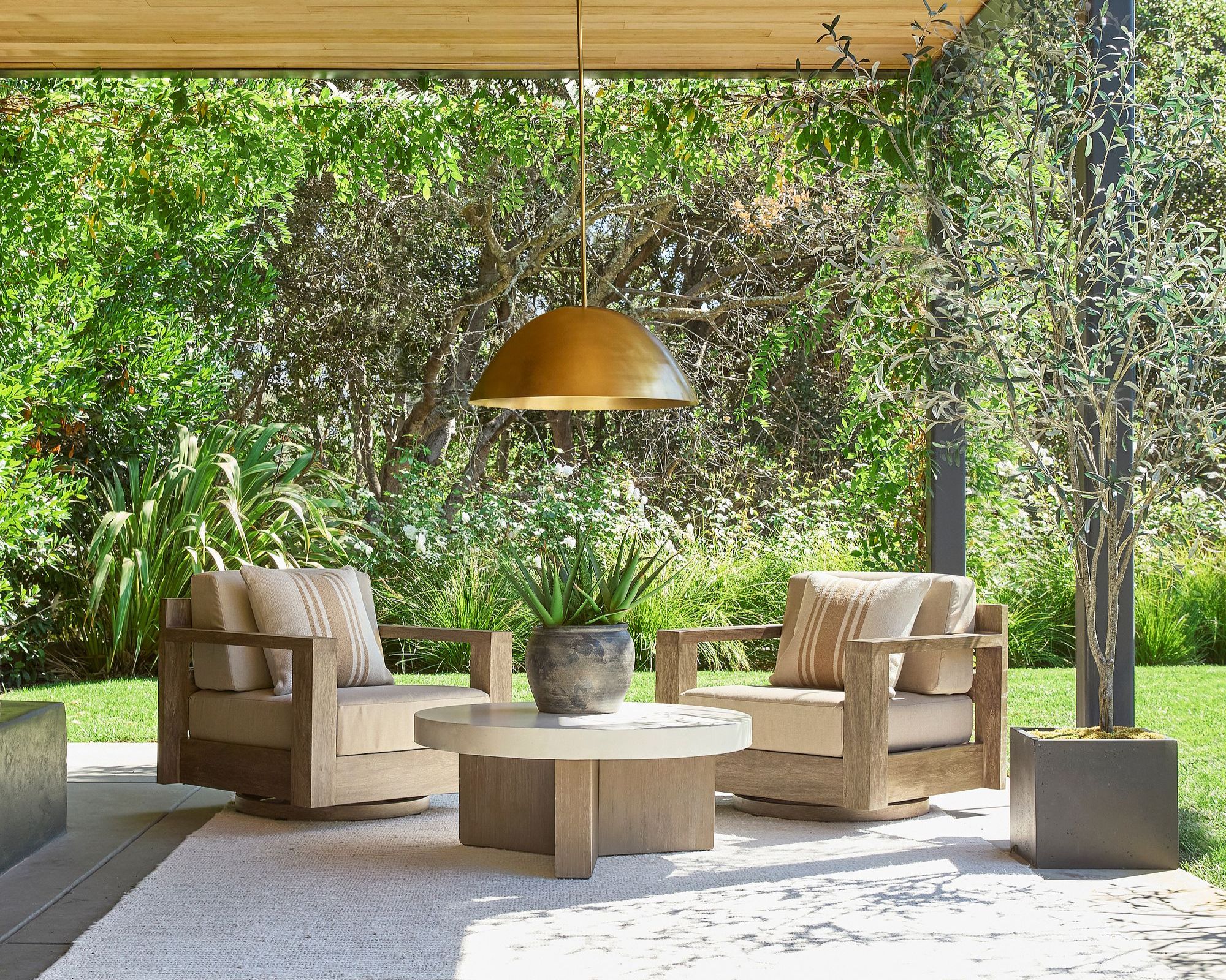 Outdoor living room, wooden and cream moth, cream carpet, grass and trees in the background
