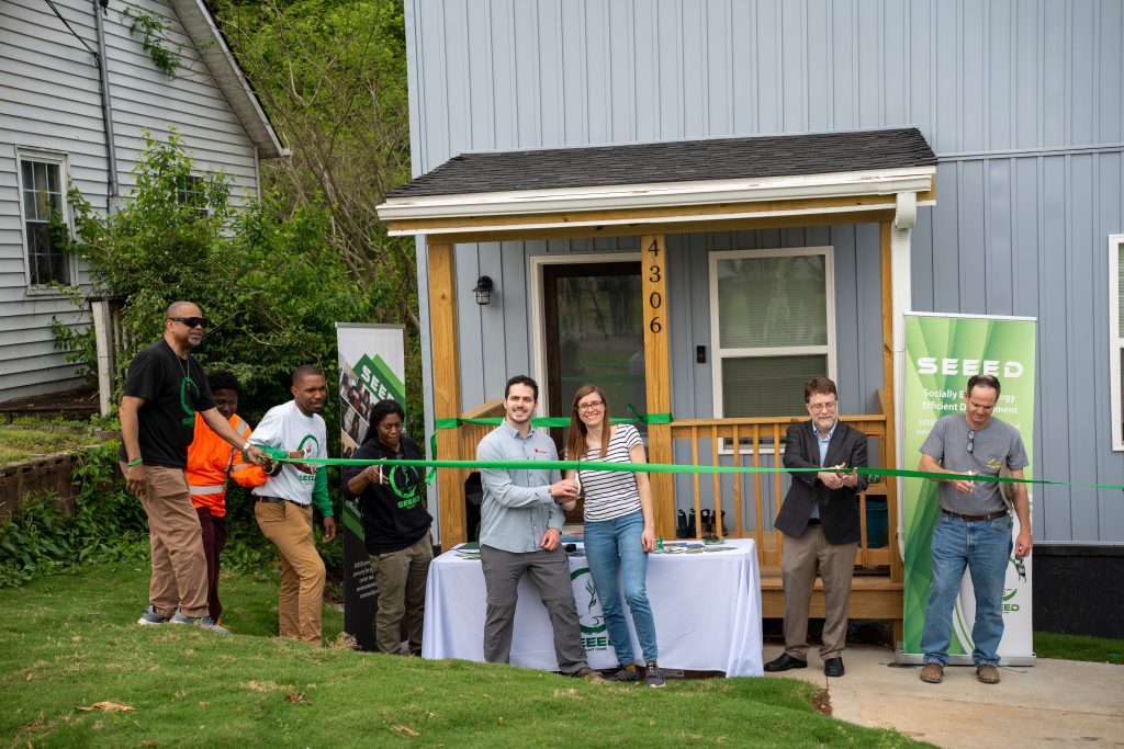 The homeowners Shawn O'Brien and Nicole Yacura cut the tape for their net-zero-solar house with representatives from Seeed, Ornl and other partners. Photo by Abby Hassler.