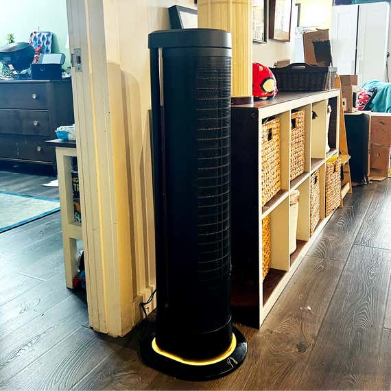 An oscillations tower fan in a room in a room.