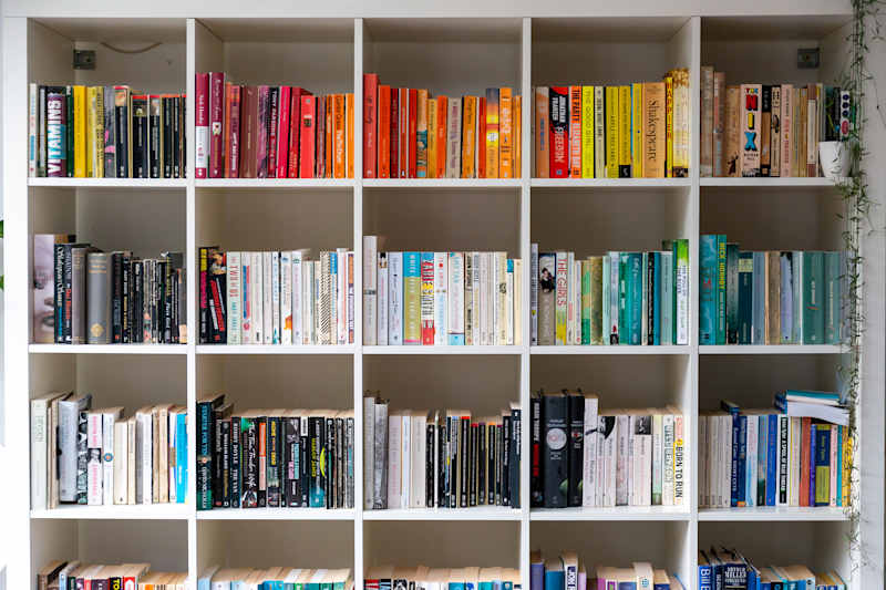 Brighton, England - August 03, 2019: White wood book trade filled with books in a British home environment