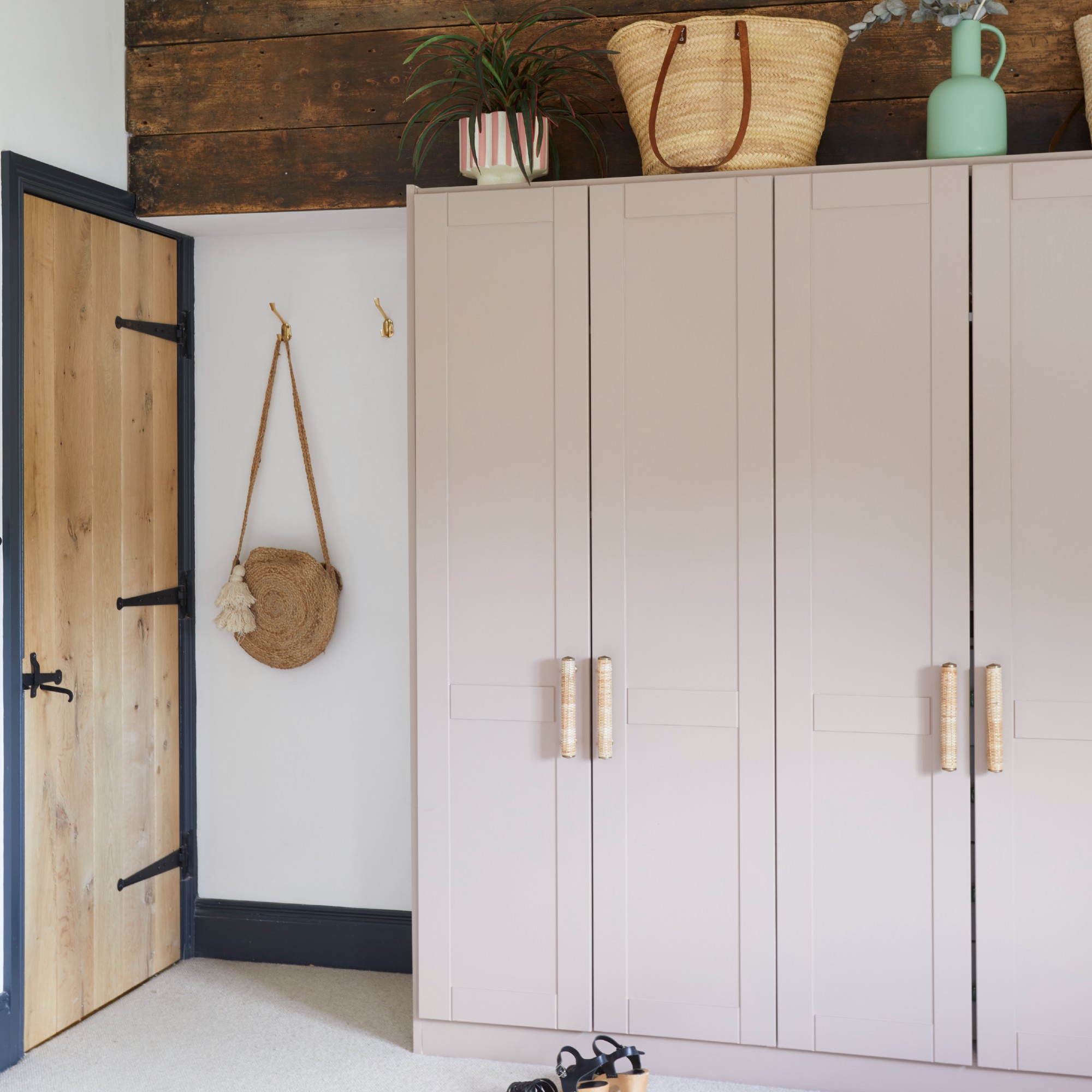 A bedroom with pink wardrobes and sculptural handles