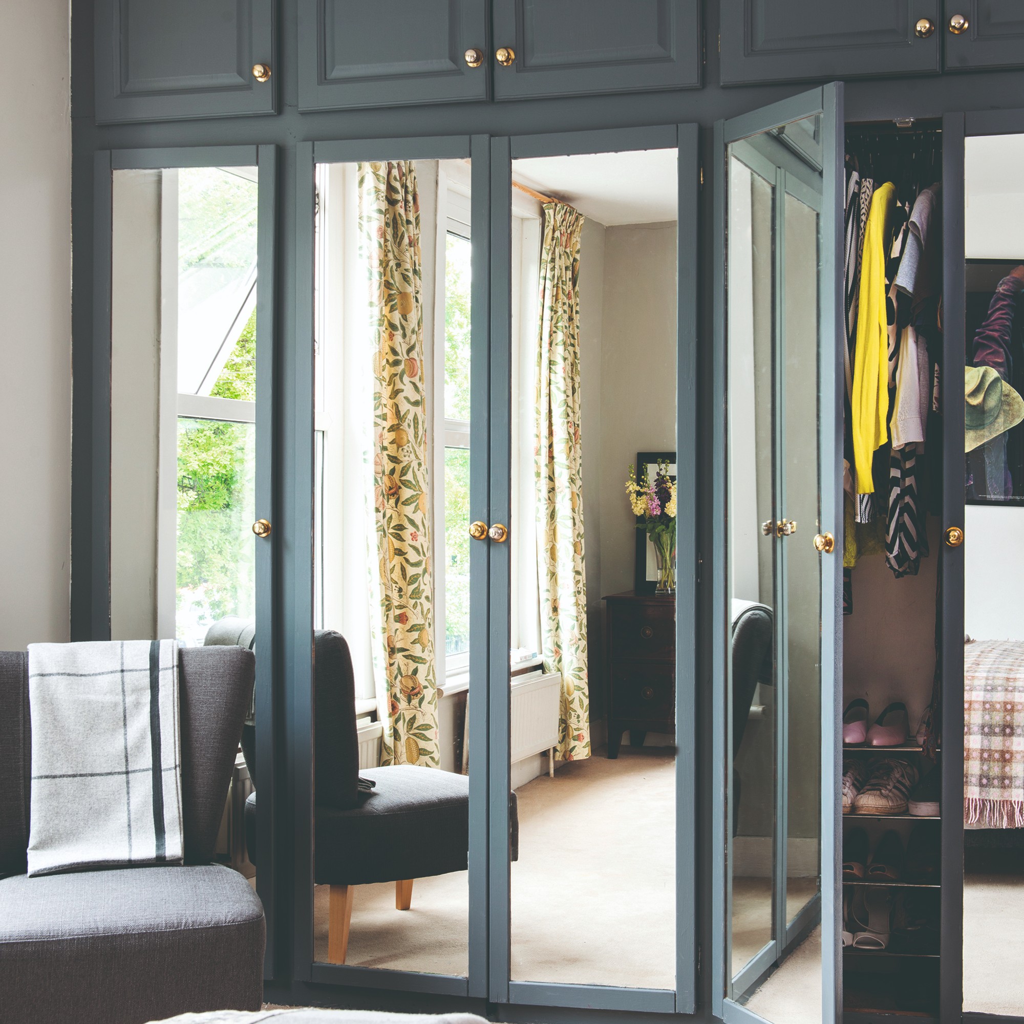 A bedroom with a built -in naval nobility with mirror plates on the doors