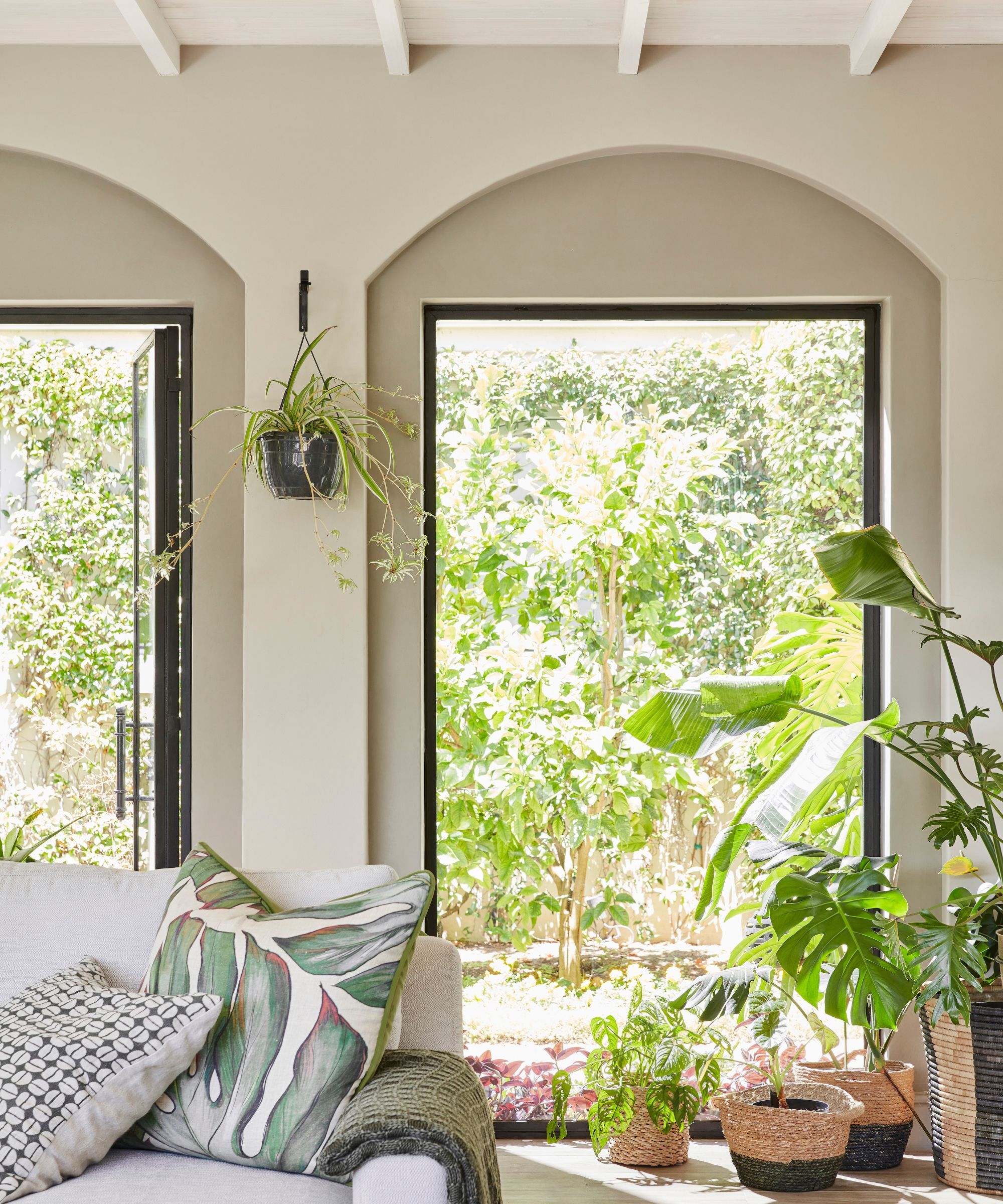 Modern living room with neutral walls and large windows to the green garden