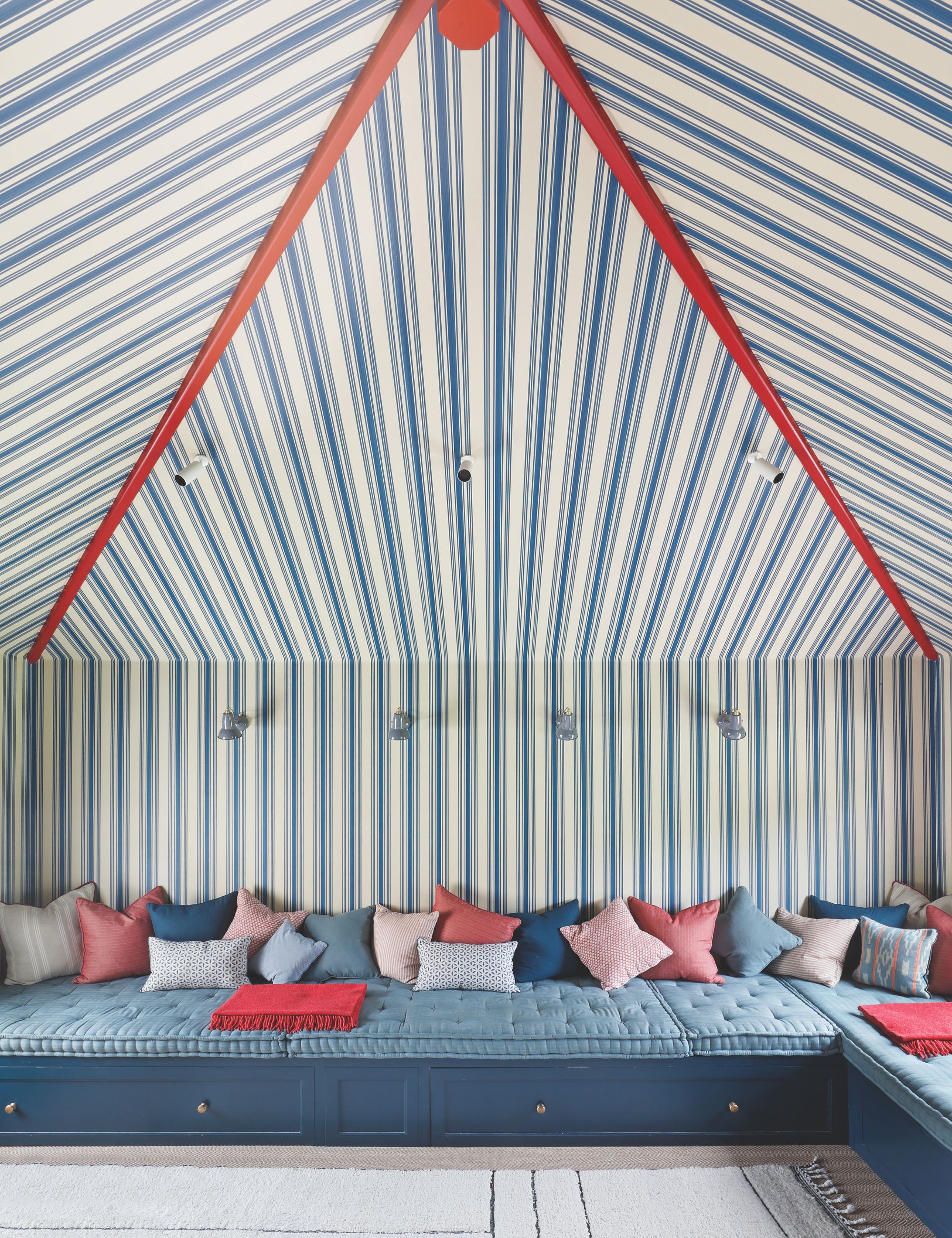 Tent toom with striped blue, red and white ceiling and walls and build seating around the edge