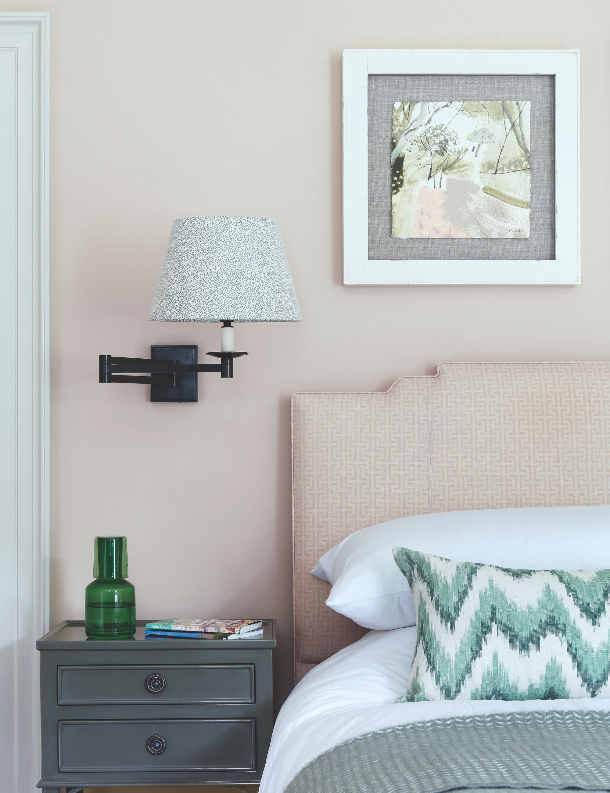 Cream Bedroom with cream headboard, black wall lamp, gray side table and white bed linen
