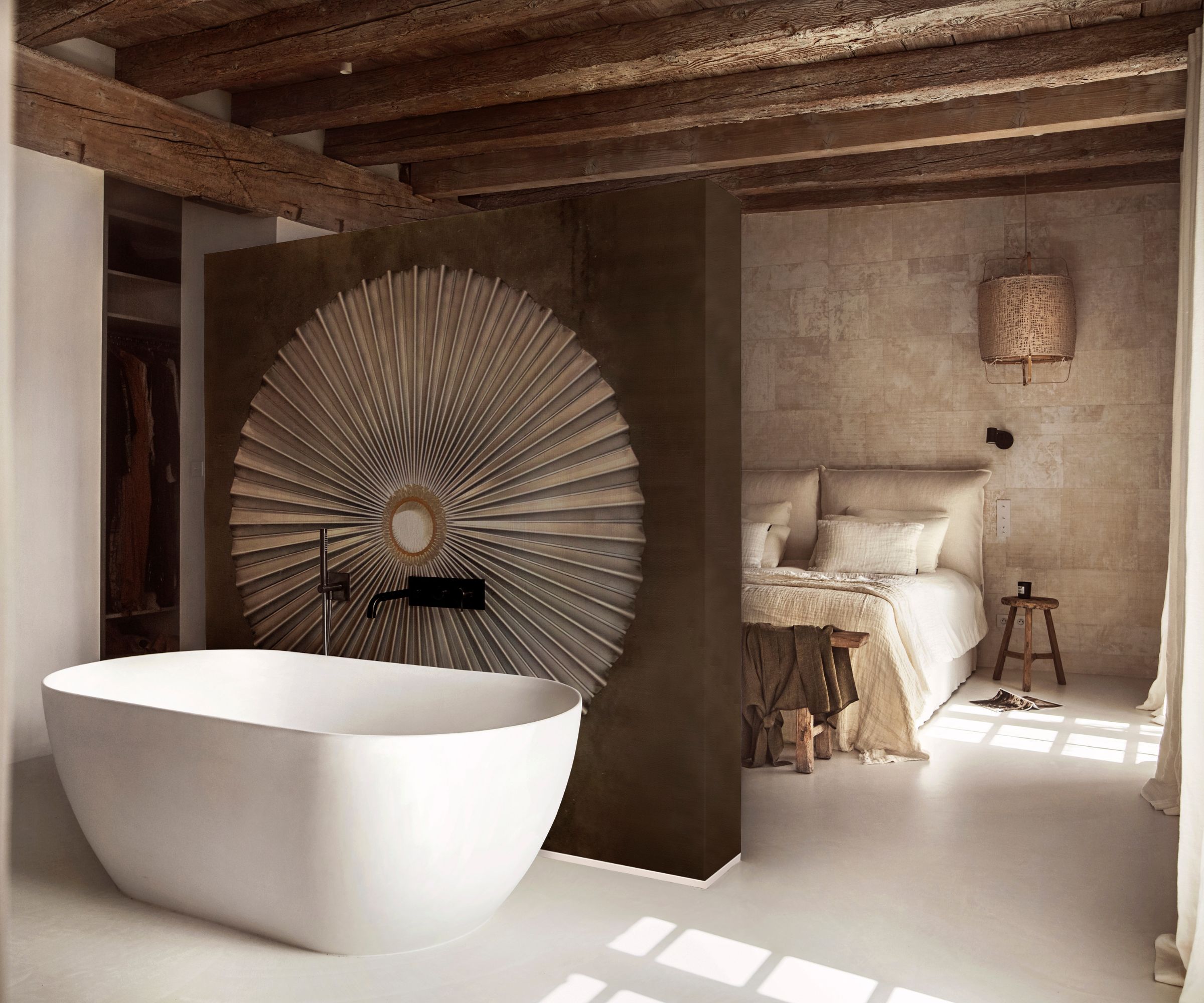 A Mediterranean bedroom with lime -white and a free -standing tub behind a divider