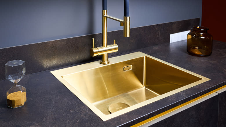Dark worktop with shiny gold sink