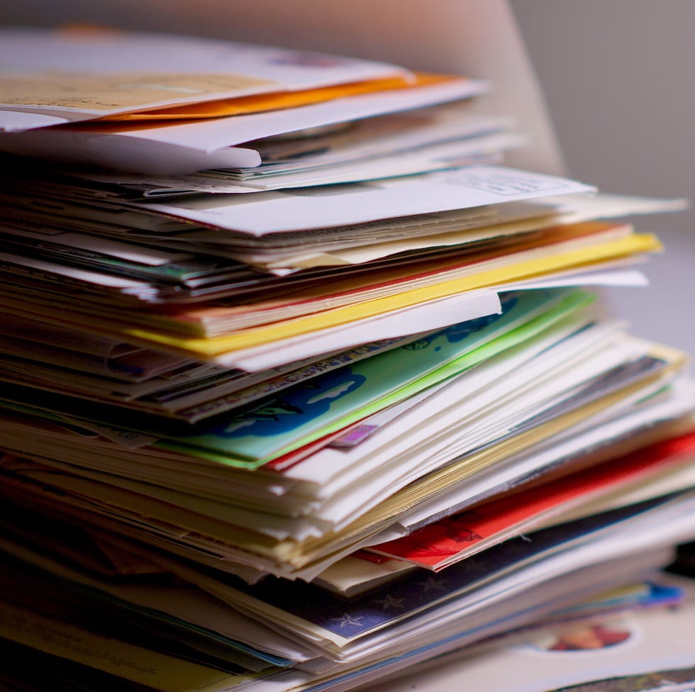 Large stacks of financial calculations, letters, maps and advertisements on a home office desk table that is waiting to be opened.