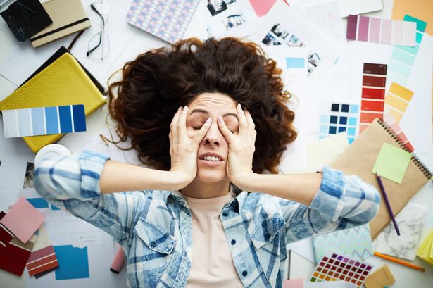 Portrait of the top view of the exhausted designer, which lies in the work pile with your eyes closed, copy room
