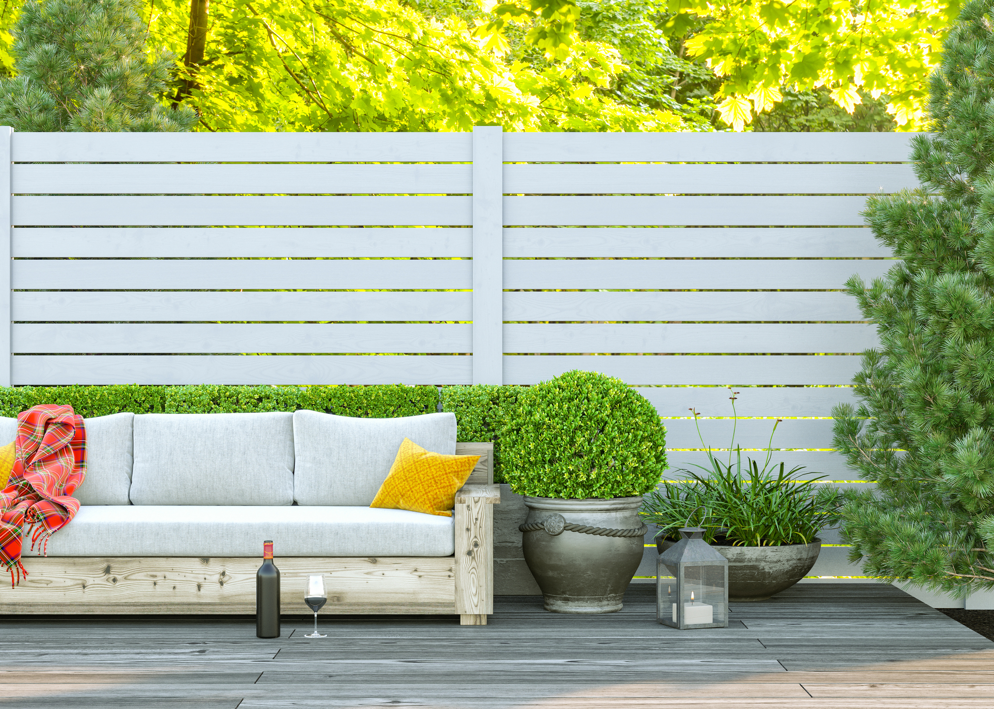 Backyard terrace with furniture and a white fence