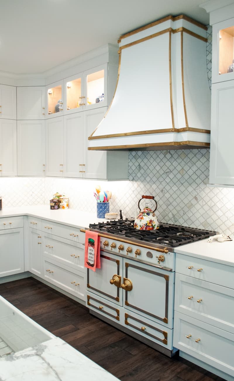 A white kitchen with golden hardware and accents