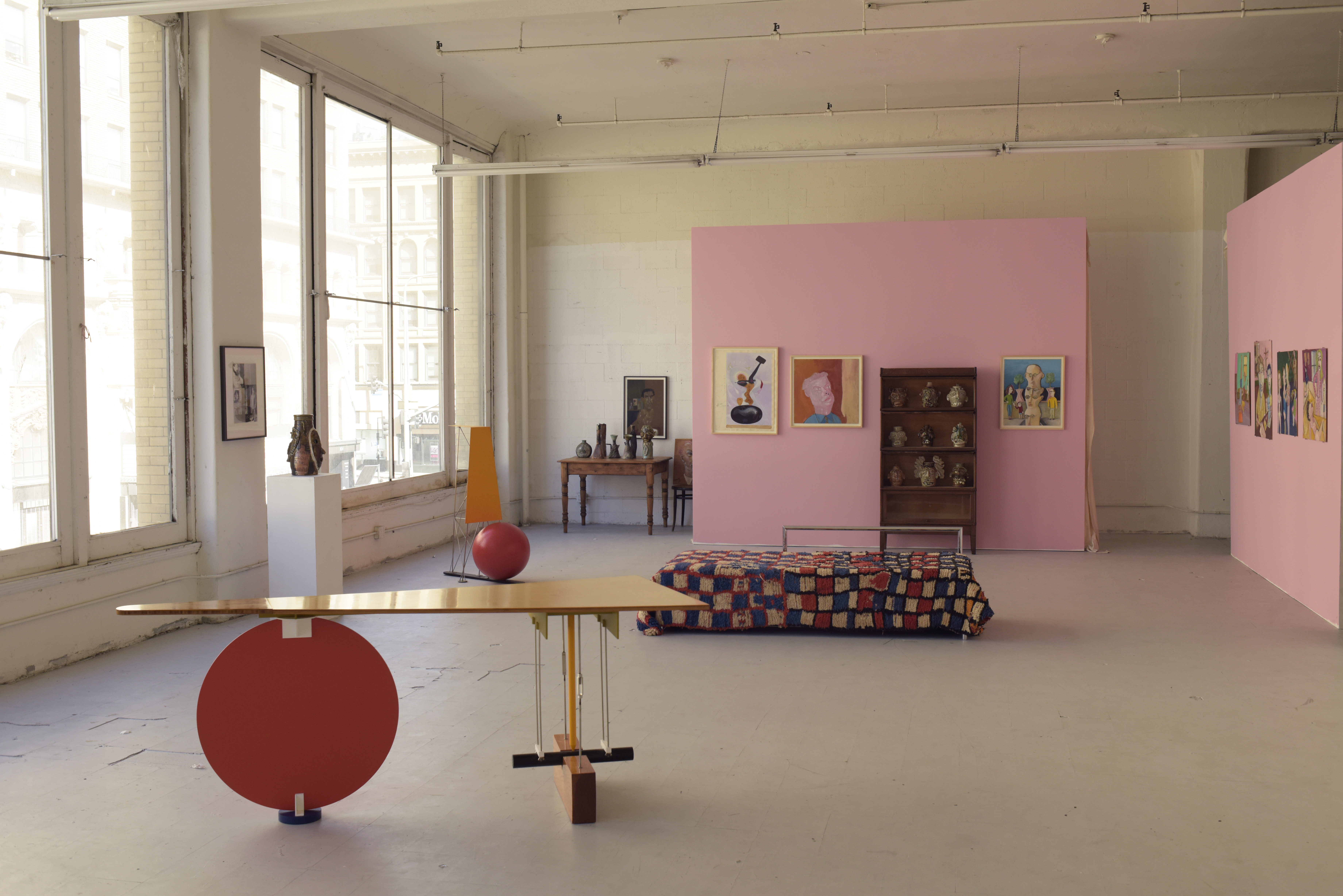 A gallery room with pink walls and contemporary furniture