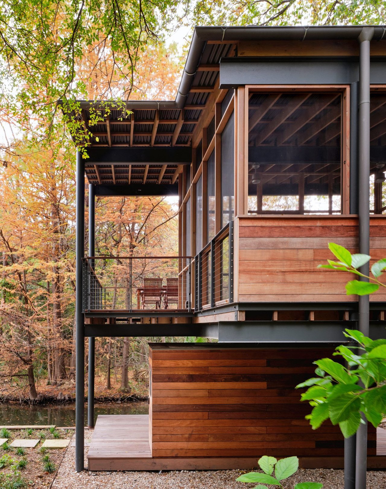 The modern pavilion swims over a stream and offers bird watching and waterfront views