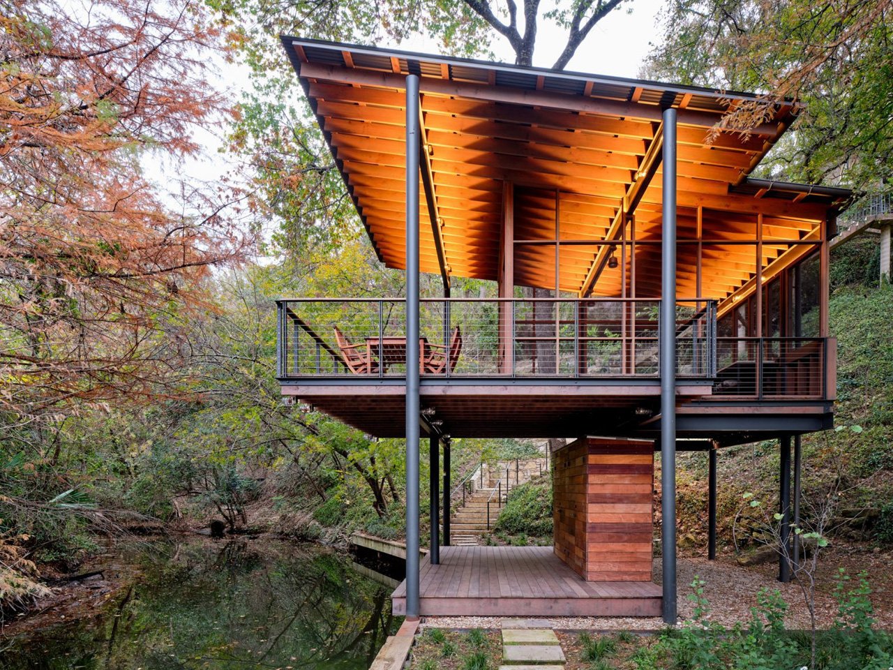 The modern pavilion swims over a stream and offers bird watching and waterfront views