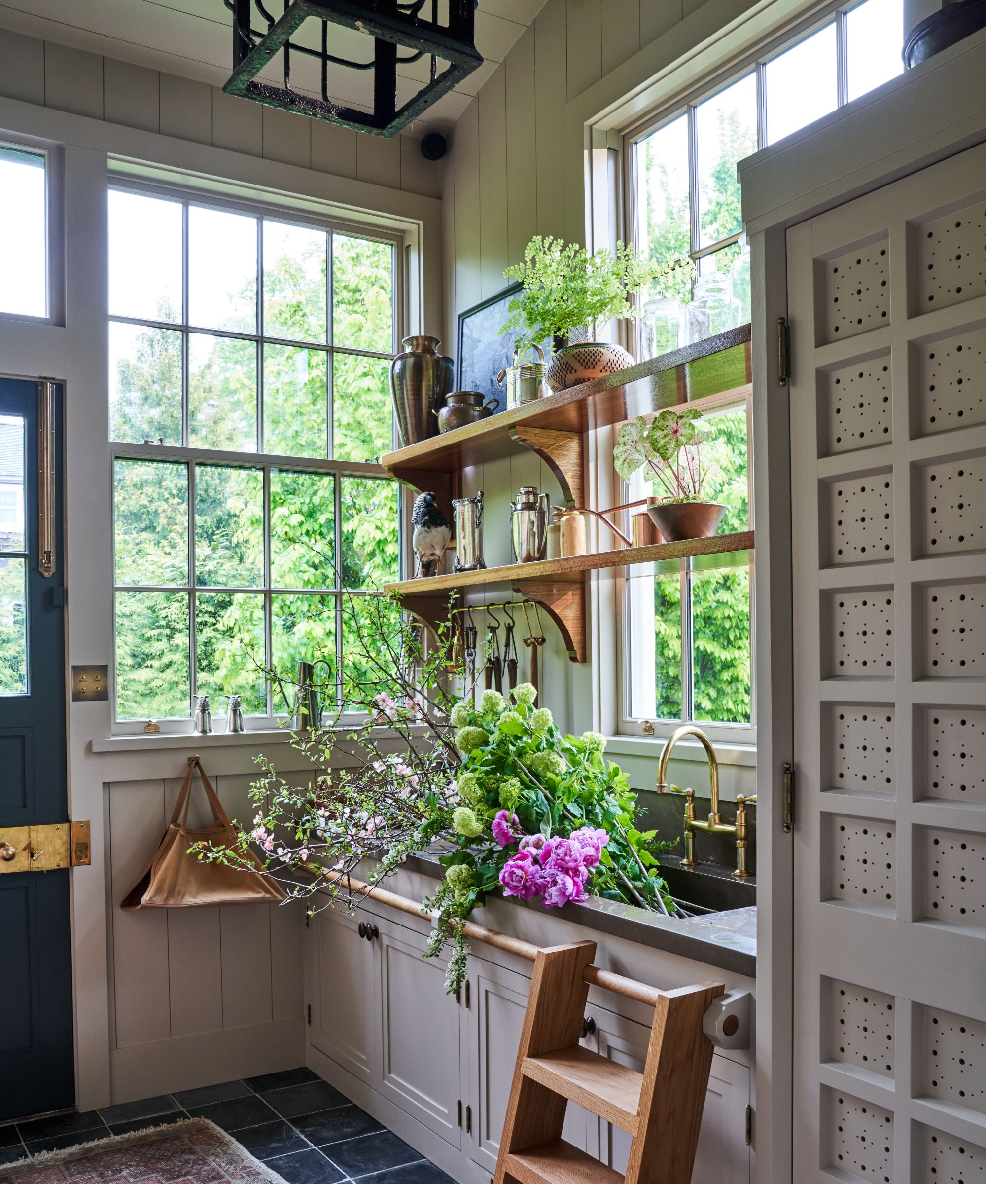 Bryan Graybill's tailoring room with a wooden ladder that is filled with flowers and shelves