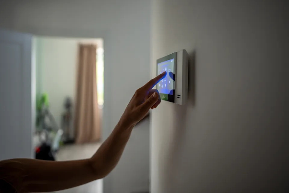 Close up with smart home touchscreen with connected device device on the wall. Set, check the heating system for energy safety for digital control in the apartment. Monitoring home automation.
