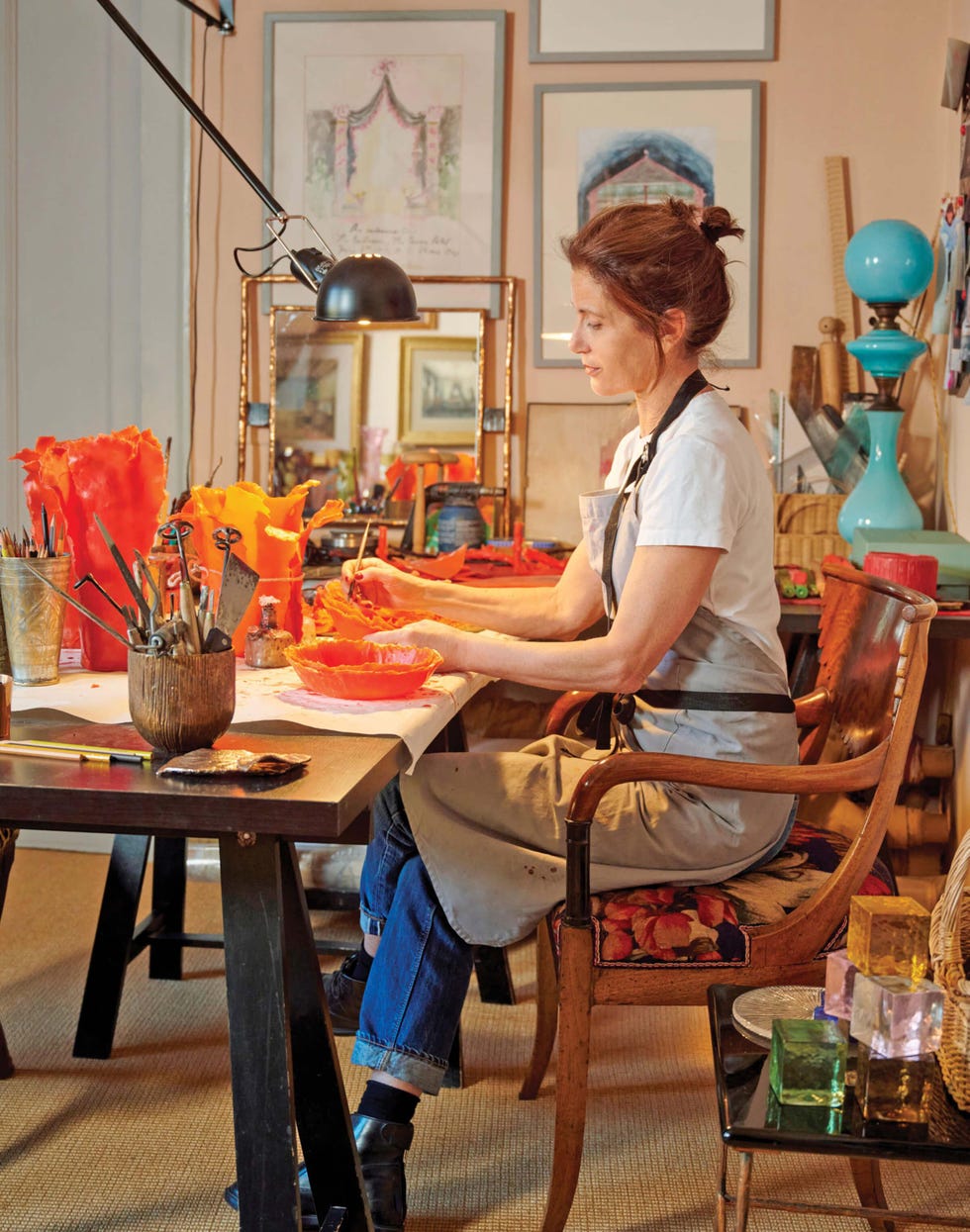 An artist who sits at a work table