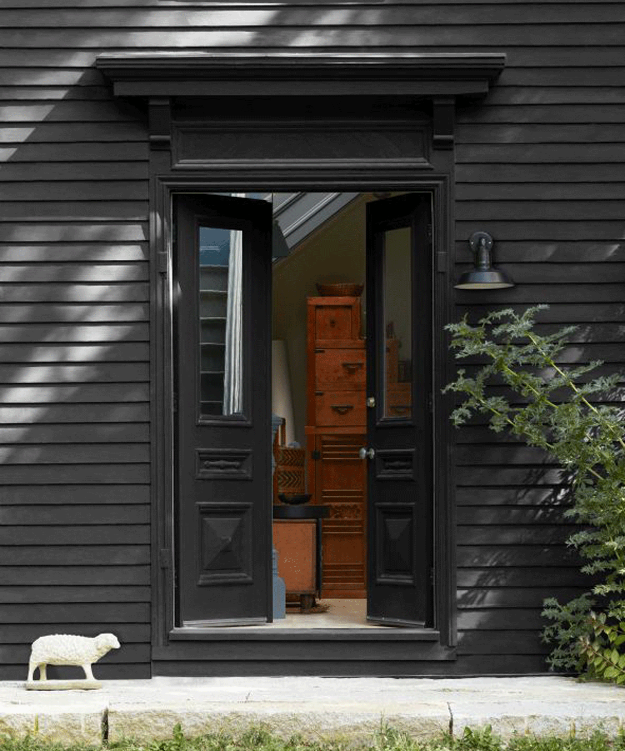 House painted out in black. The doors are open to a living room and there seems to be a little sun on the outdoor paneling.