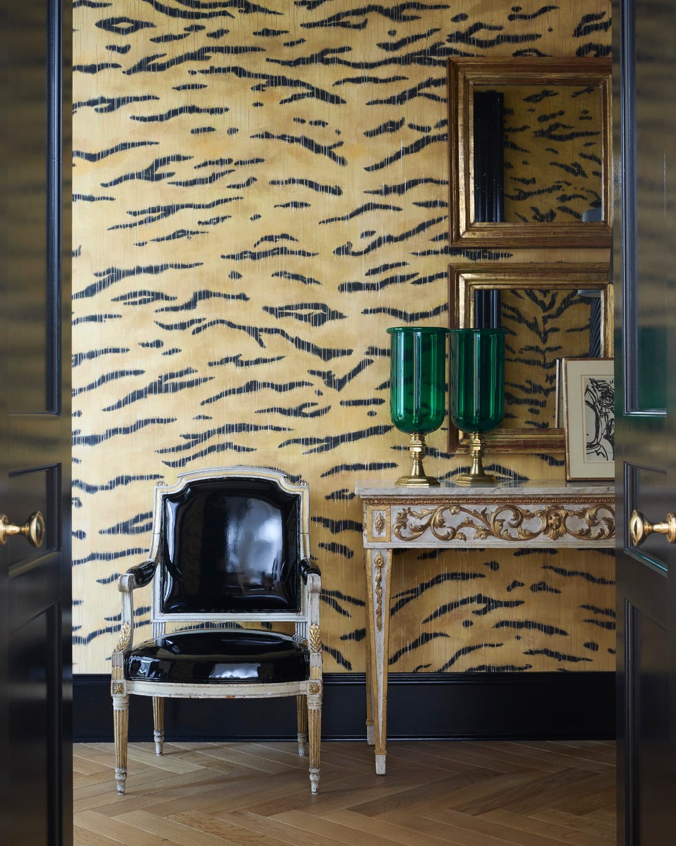 Call with tiger printing wallpaper, black equipment, black chair and mirror over a narrow table