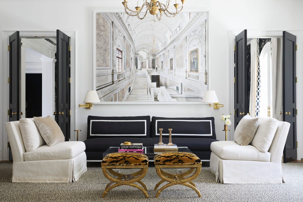 Living room with black sofa, white chairs, tiger pressure coffee and wall art
