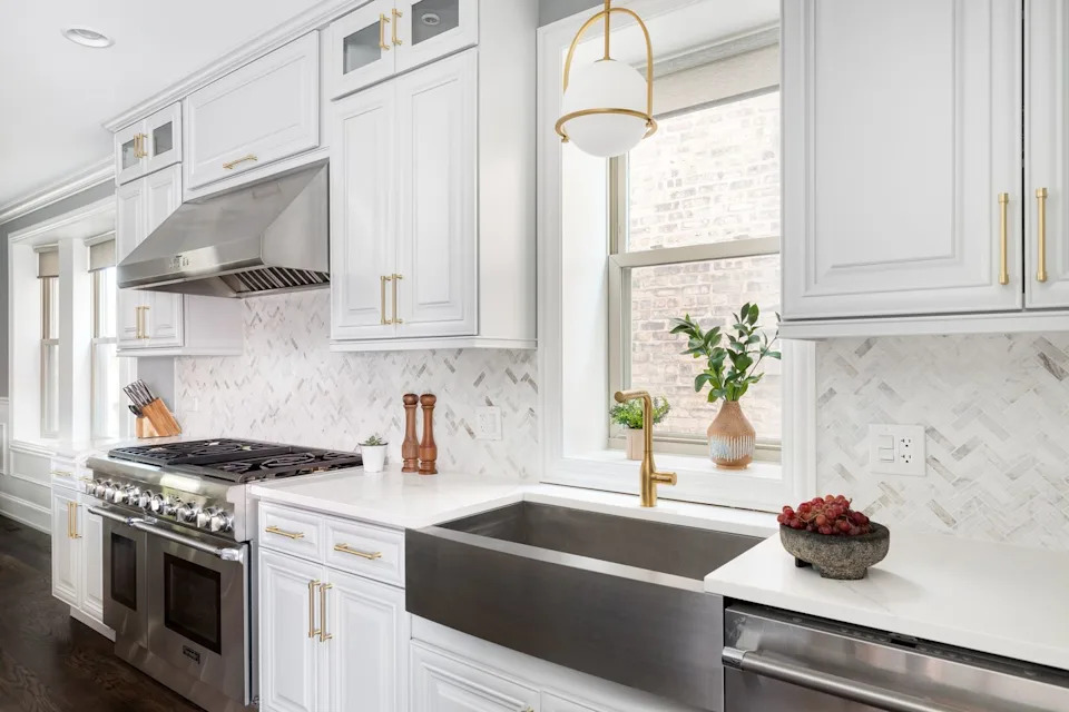 A beautiful kitchen with gray cupboards and stainless steel devices.