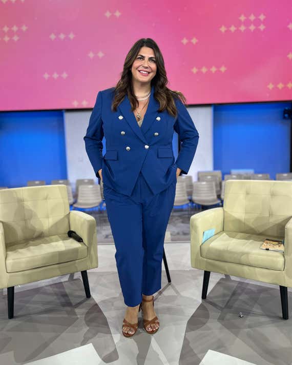 Katie Sturino wears a blue Veronica barn alongside some chairs in the Oprah recording studio.