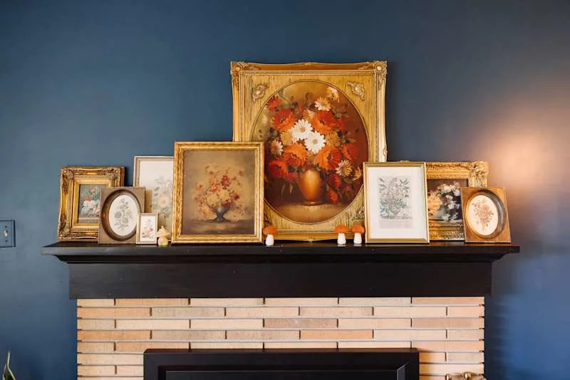 Vintage floral prints and paintings above the coat in the blue painted living room.