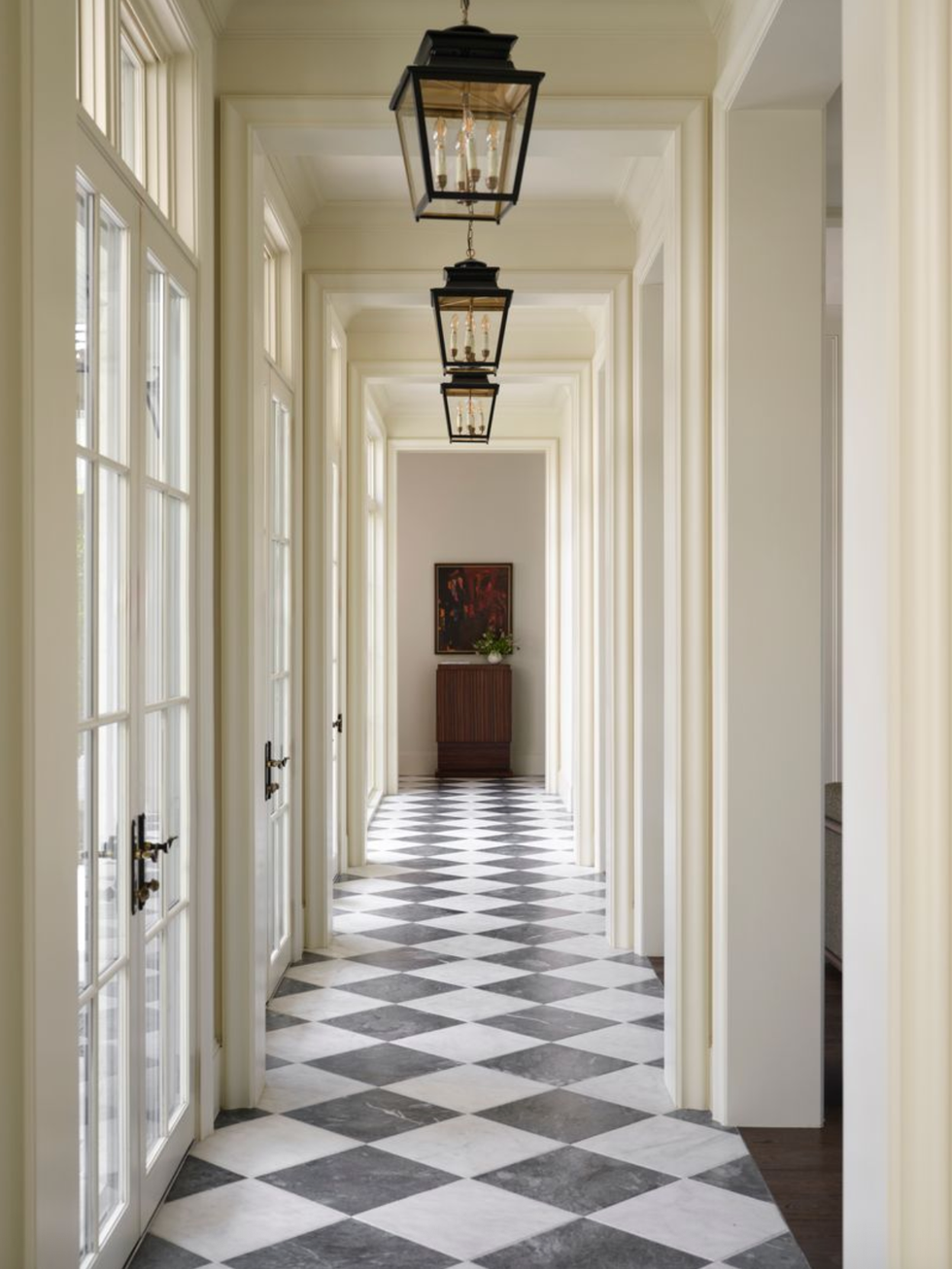 Elegant hallway with a checkered floor, lantern lights and high windows.