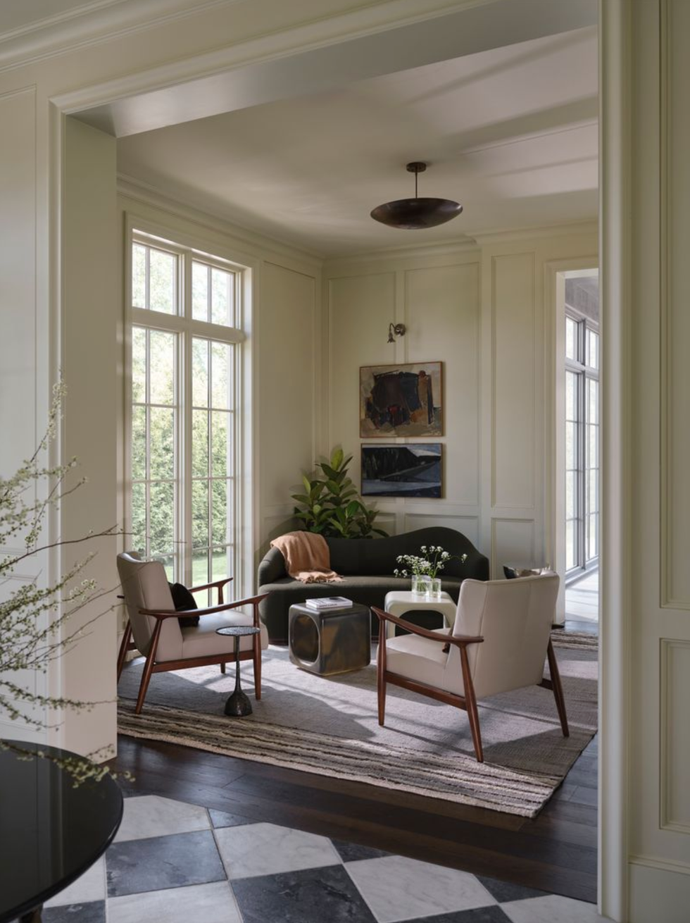 Sun mountains with armchairs, sofa and wall art of large windows.