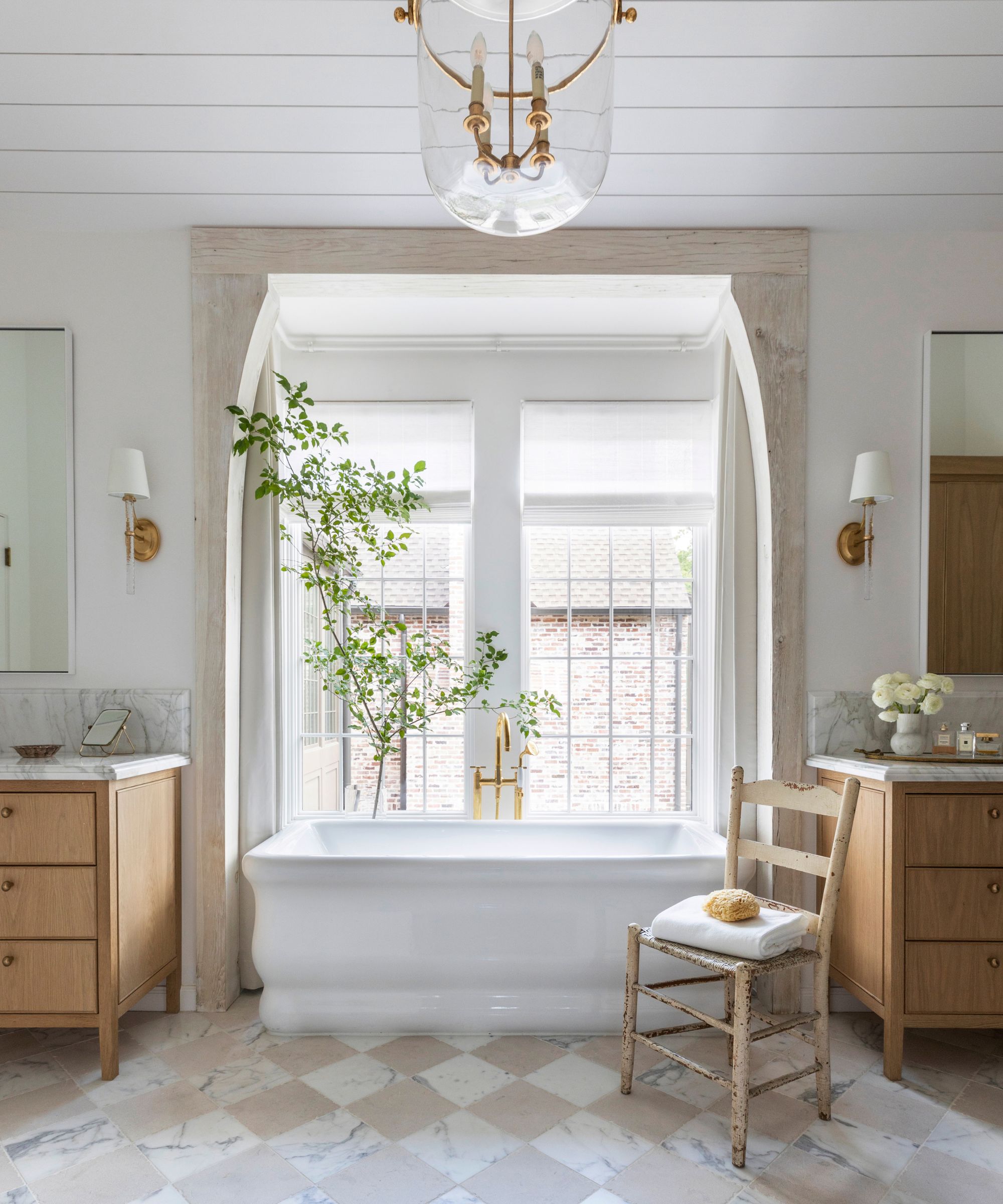 Neutral bathroom with chessboard tile floor white bathtub and two wooden washbasin