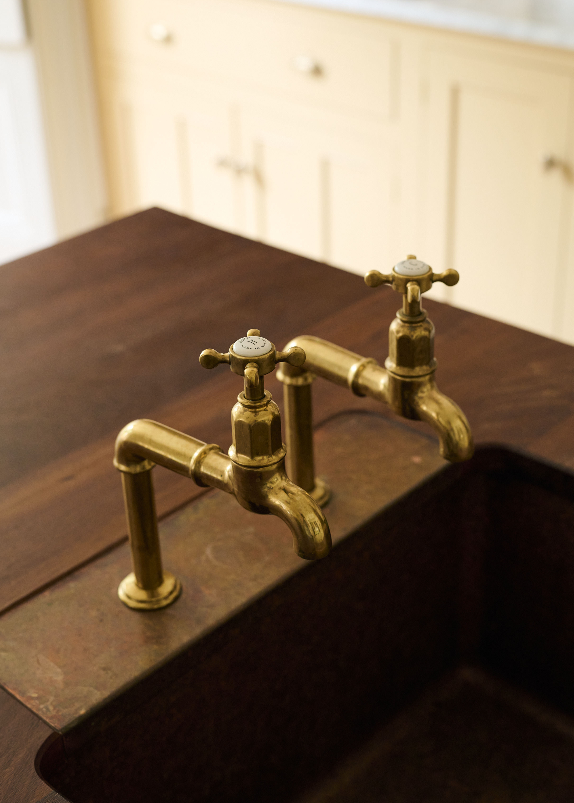A close -up of the gold tap with a brown marble insert behind a wooden switch