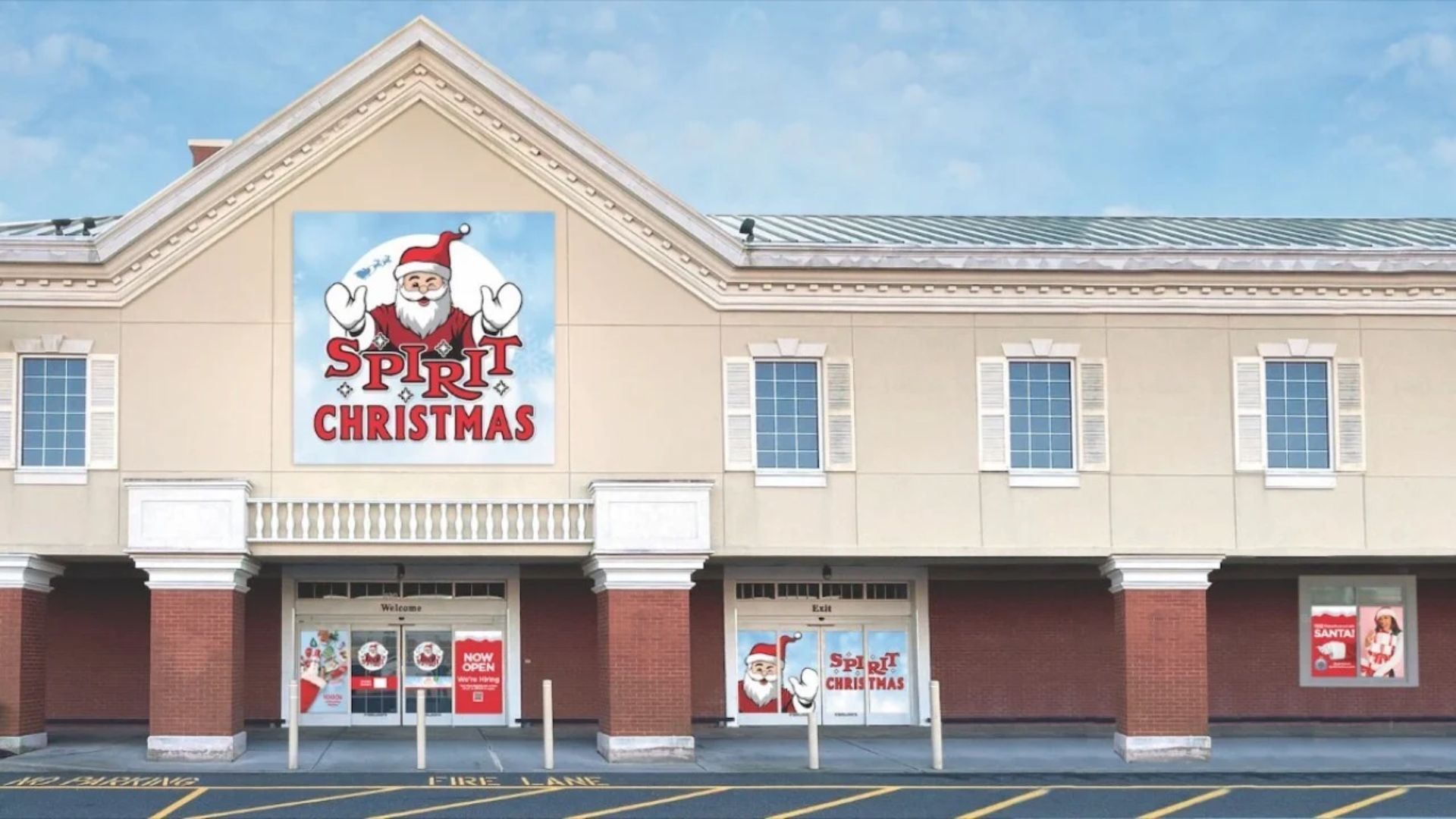 The front of a beige and red storefront with a large "Spiritual Christmas" Sign saying “Santa Claus”. Festive windows hint at the magic of Spirit's Christmas locations. The clear blue sky shines above you, welcoming you to Spirit Christmas 2025.