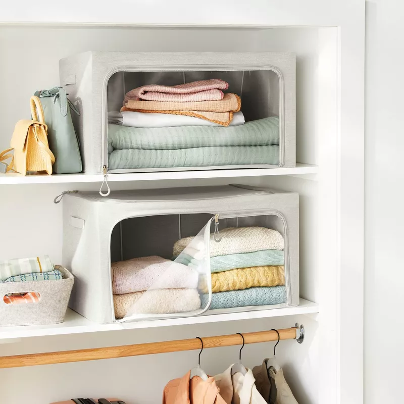 Two clear clothing storage boxes on the front of the closet shelves