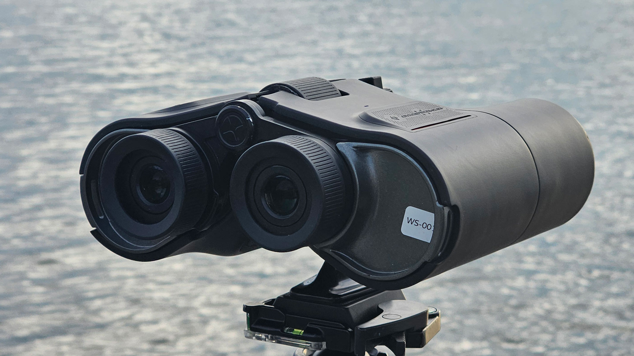 A rear view of the Unistellar Envision smart binoculars with water in the background.