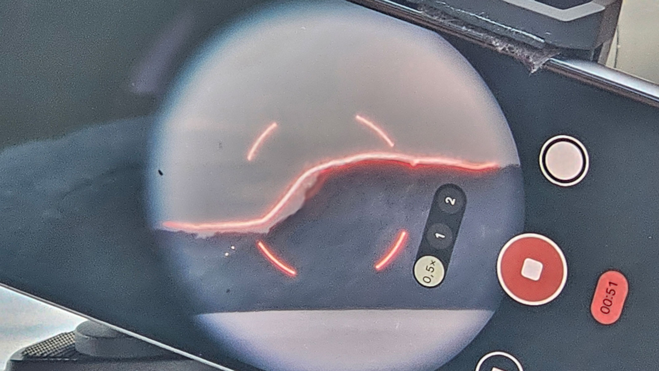 A smartphone showing the view through Unistellar Envision binoculars with a red AR overlay of a mountain.