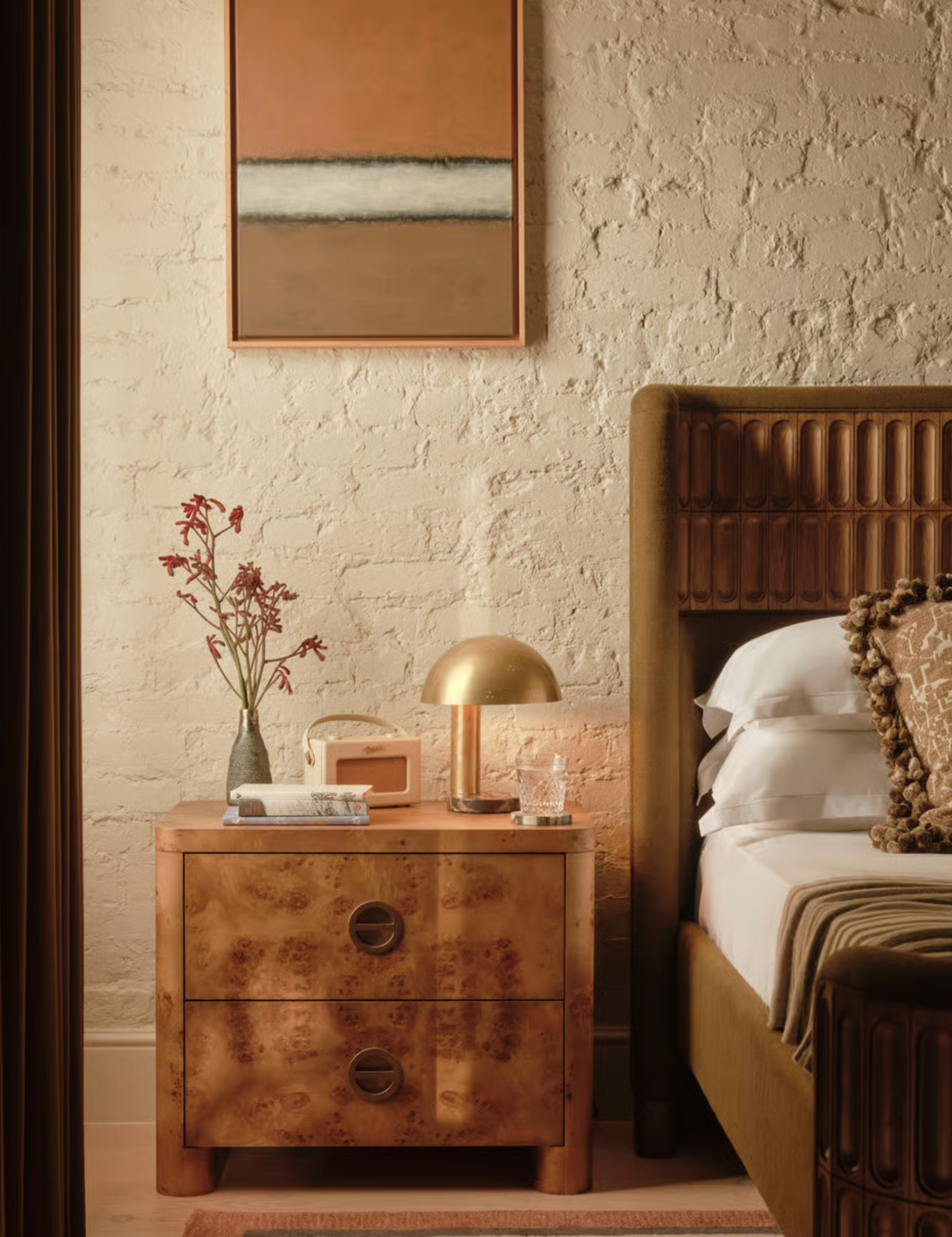 Burlwood night table in a bedroom with a warm neutral color palette in a bedroom in the middle of the century