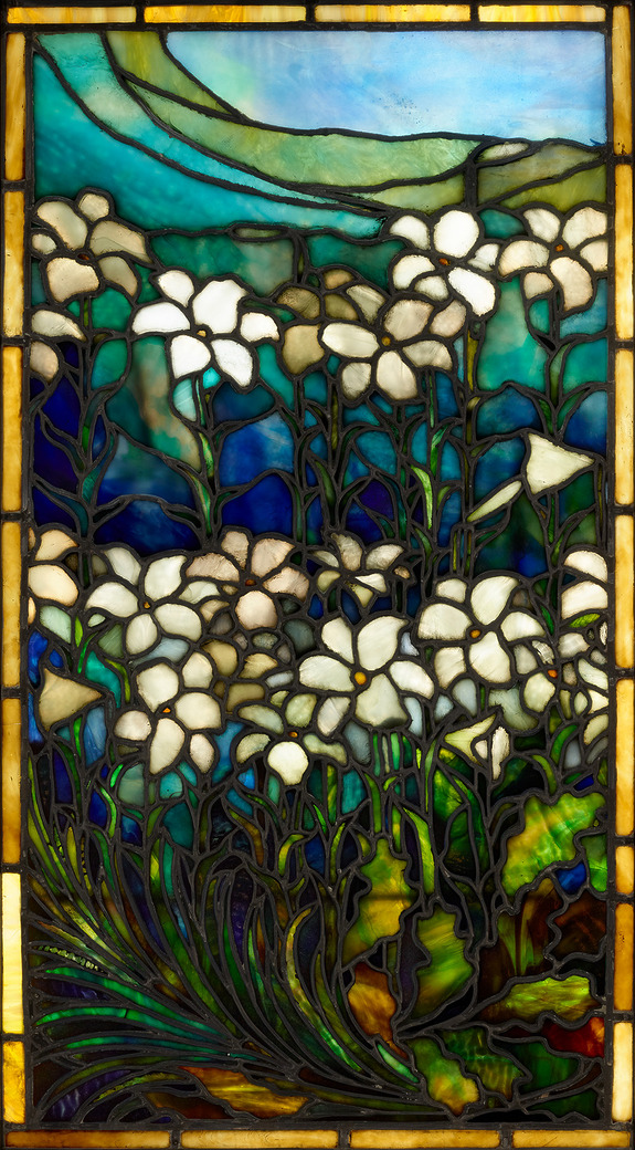 Stained glass artwork depicting white flowers with green leaves against a bright blue and green background.
