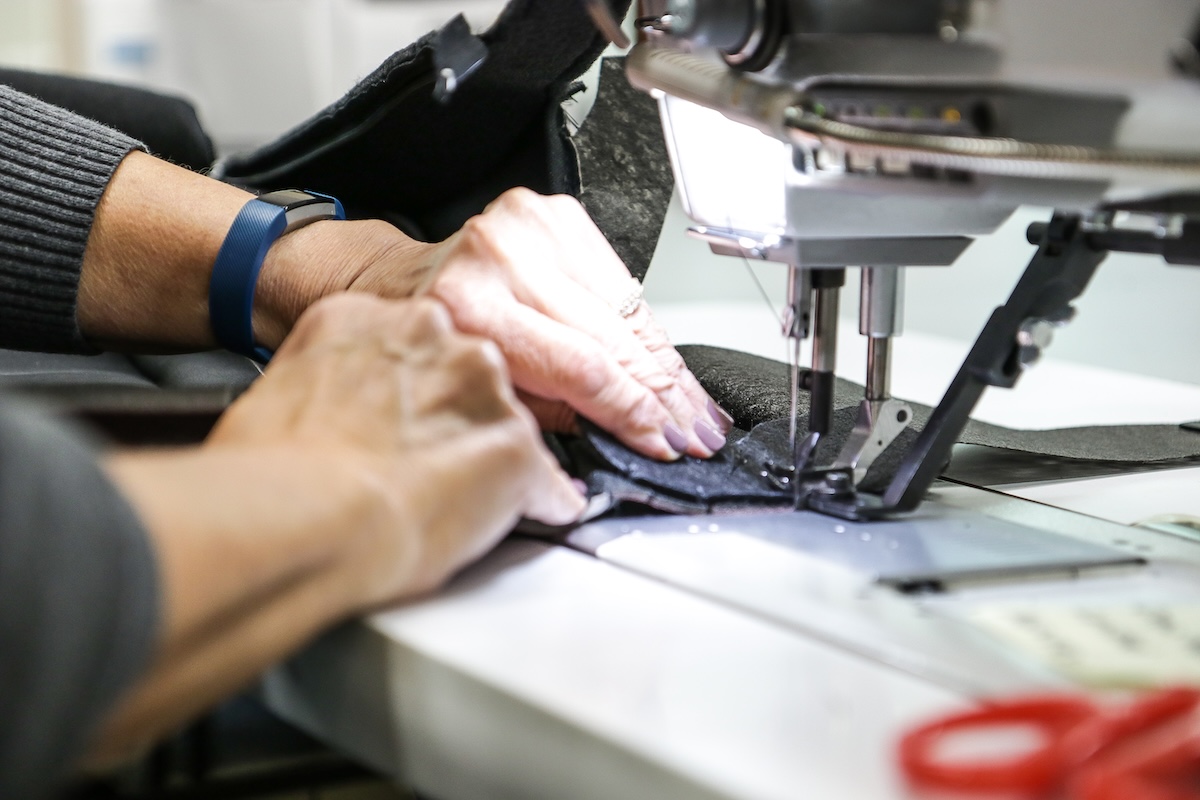 Car interior, bridge of weir/piston interior, hands working sewing machine, close-up
