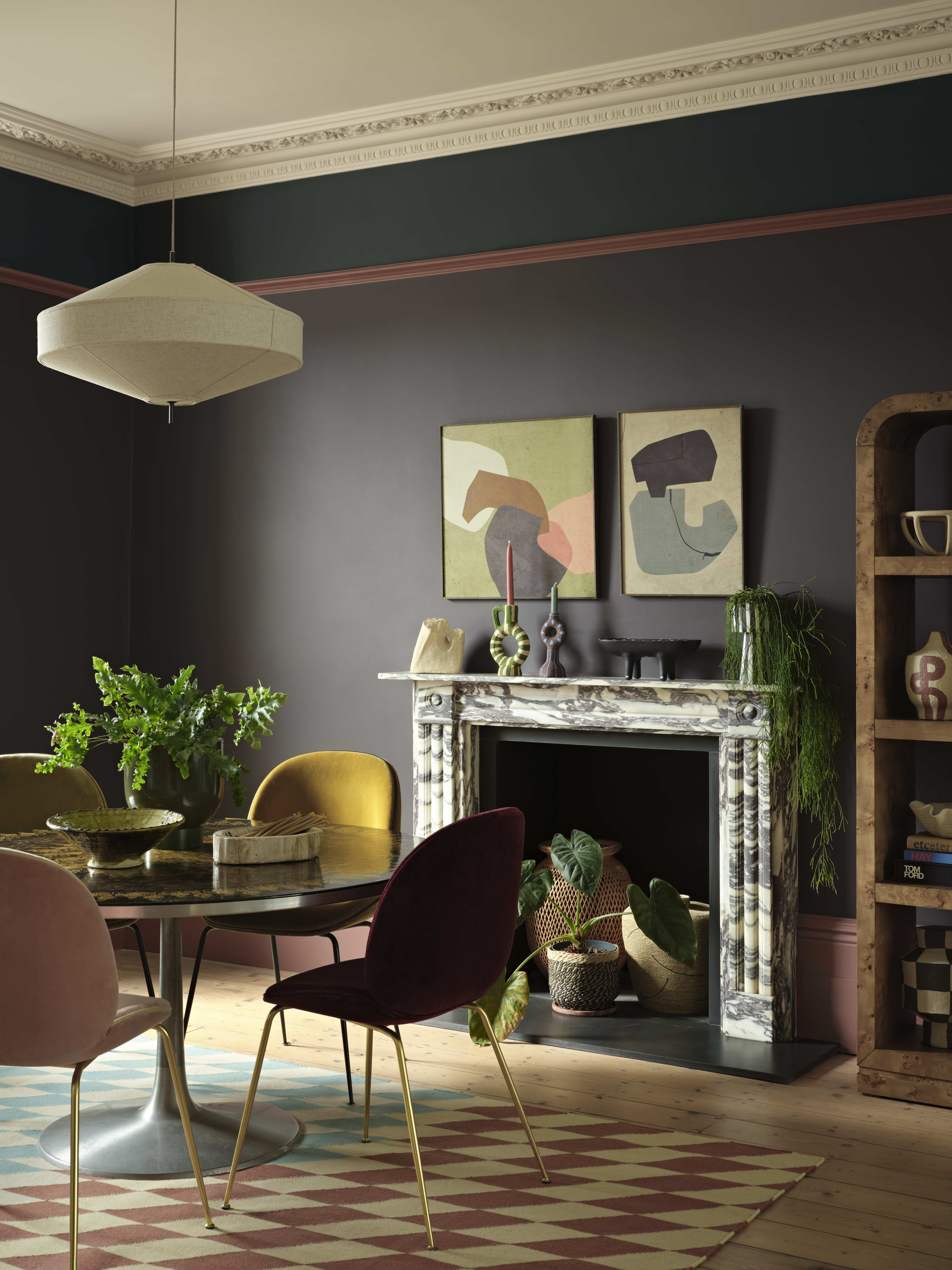 A picture of a dining area in front of a fireplace with walls painted deep brown.